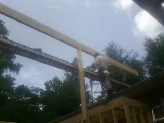 Carpenter setting a ridge beam over a new addition frame — Ice Dam Removal by Roofing Brothers in Big Sky